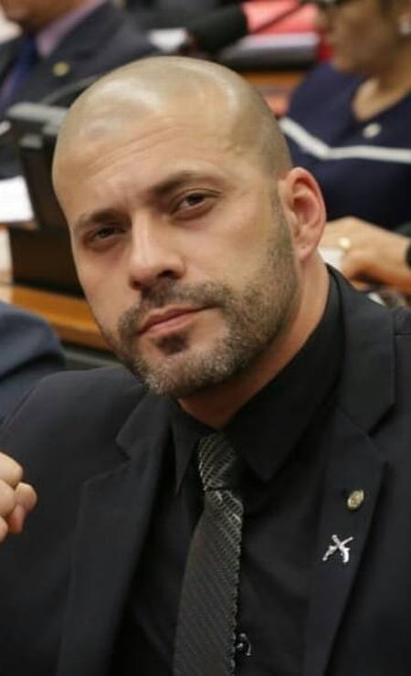 Com broche de armas na lapela do paletó, Daniel posa na Câmara dos Deputados Foto: Reprodução / Agência O Globo